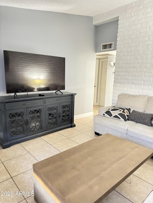 living room with light tile patterned floors, baseboards, visible vents, and a textured ceiling