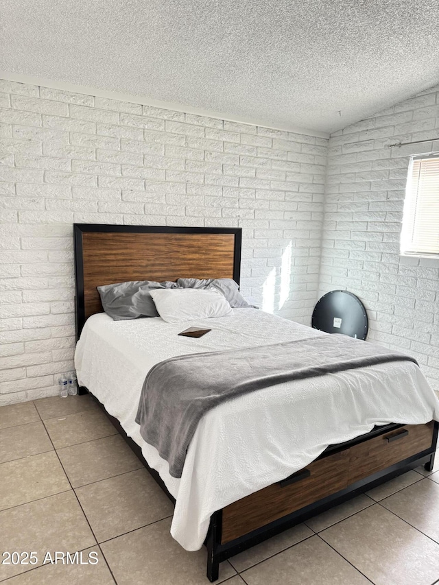 tiled bedroom featuring a textured ceiling, brick wall, and vaulted ceiling