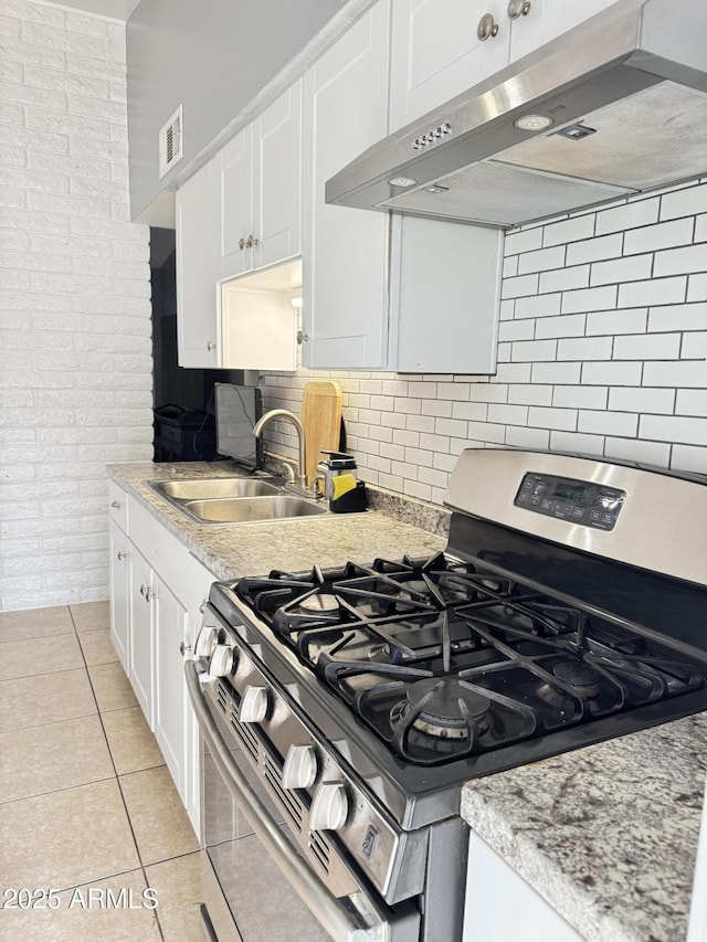 kitchen featuring visible vents, stainless steel range with gas cooktop, a sink, under cabinet range hood, and white cabinetry