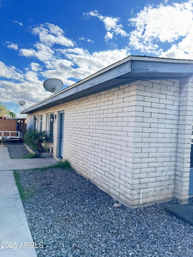 view of side of home with brick siding