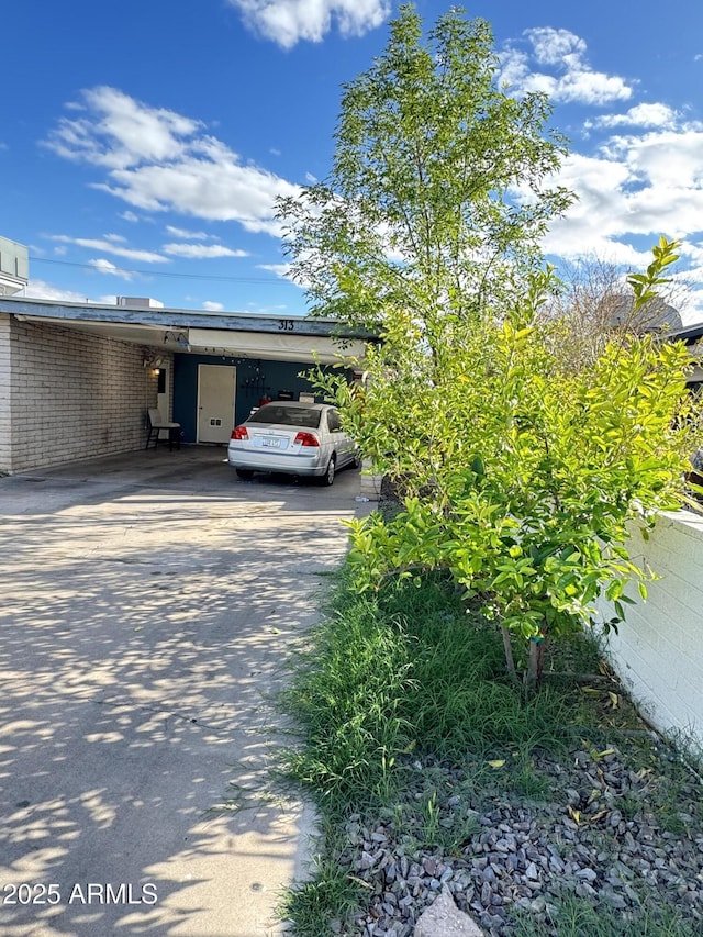 view of car parking featuring concrete driveway and a carport