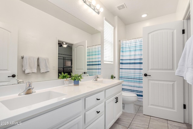 2562 N Springfield St, Buckeye, AZ 85396 - full bath featuring toilet, double vanity, tile patterned floors, a shower with shower curtain, and a ceiling fan