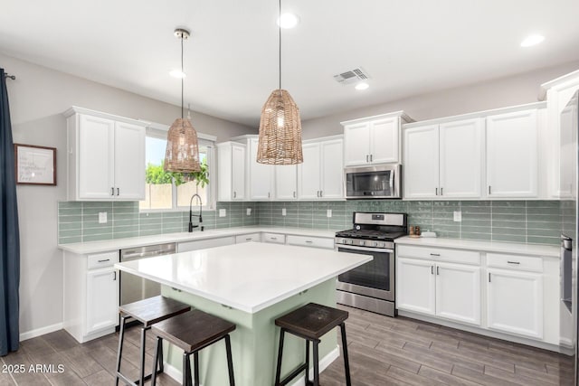 2562 N Springfield St, Buckeye, AZ 85396 - kitchen with stainless steel appliances, a breakfast bar, light countertops, wood finished floors, and recessed lighting