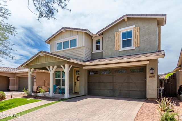 2562 N Springfield St, Buckeye, AZ 85396 - view of front of home with decorative driveway, an attached garage, a porch, and stucco siding