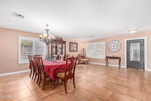 dining space with light tile patterned floors and a notable chandelier