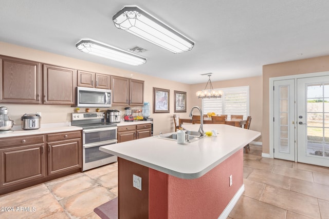 kitchen featuring appliances with stainless steel finishes, pendant lighting, sink, a chandelier, and a kitchen island with sink