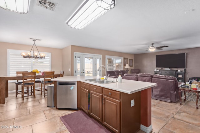 kitchen with sink, ceiling fan with notable chandelier, an island with sink, hanging light fixtures, and dishwasher