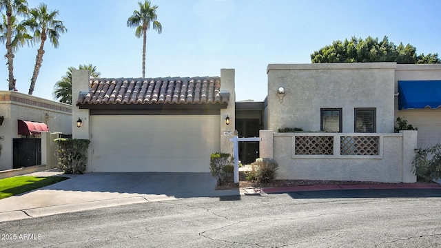 view of front facade with stucco siding, driveway, a tile roof, and a garage