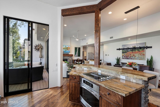 7272 E Gainey Ranch Rd Unit 29, Scottsdale, AZ 85258 - kitchen featuring stainless steel oven, black electric cooktop, wood finished floors, open floor plan, and a ceiling fan