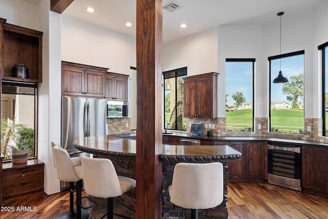 7272 E Gainey Ranch Rd Unit 29, Scottsdale, AZ 85258 - kitchen featuring beverage cooler, dark wood-style floors, a kitchen breakfast bar, backsplash, and recessed lighting