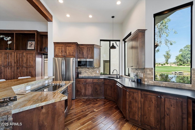 7272 E Gainey Ranch Rd Unit 29, Scottsdale, AZ 85258 - kitchen with stainless steel appliances, dark wood-style flooring, decorative backsplash, a sink, and decorative light fixtures