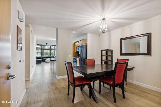 dining area featuring light wood-type flooring and a chandelier