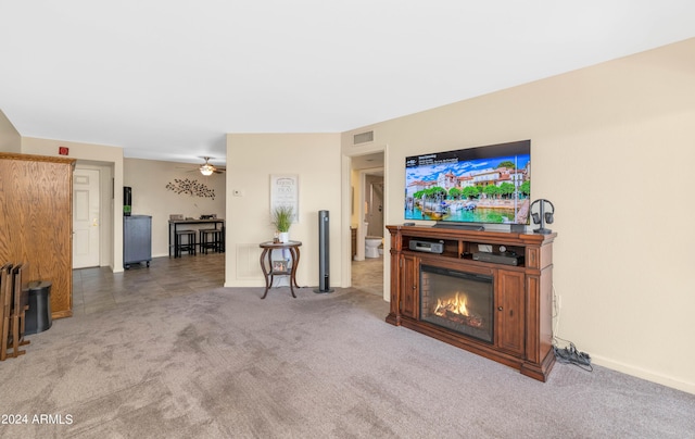 17404 N 99th Ave Unit 108, Sun City, AZ 85373 - carpeted living room featuring ceiling fan, a glass covered fireplace, and baseboards