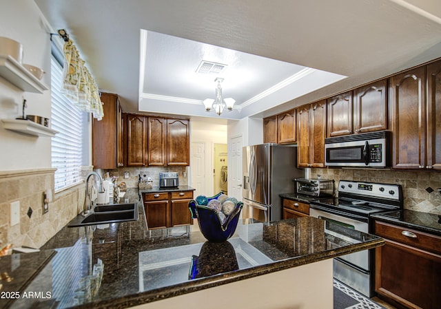 kitchen featuring a sink, visible vents, a raised ceiling, and appliances with stainless steel finishes