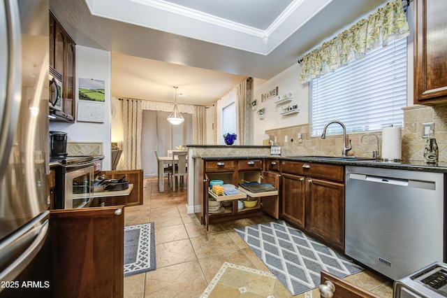 kitchen featuring a raised ceiling, a sink, tasteful backsplash, and appliances with stainless steel finishes