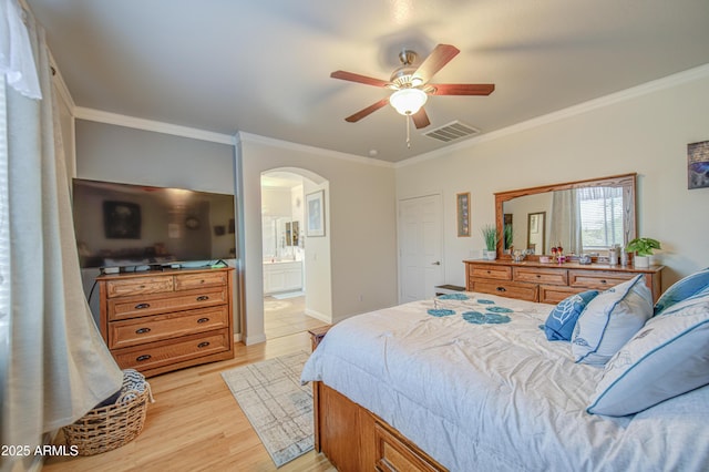 bedroom featuring arched walkways, crown molding, light wood finished floors, and visible vents