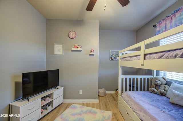 bedroom featuring a ceiling fan, light wood-style flooring, and baseboards