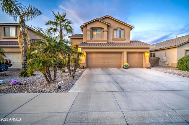 view of front facade featuring a tile roof, stucco siding, a garage, and concrete driveway