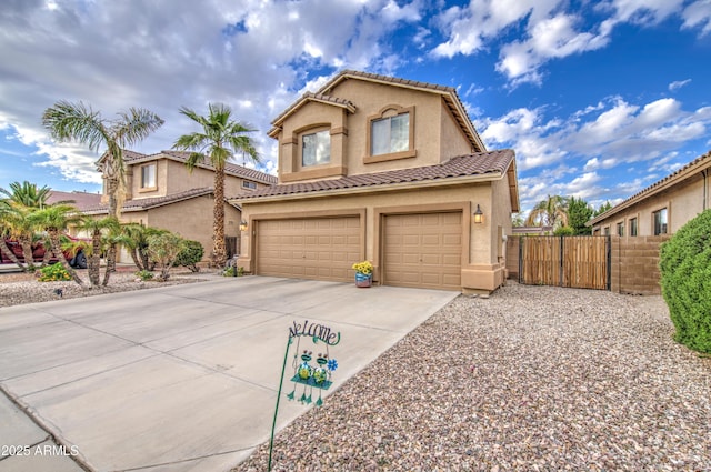 mediterranean / spanish-style house with a tile roof, concrete driveway, stucco siding, fence, and a garage