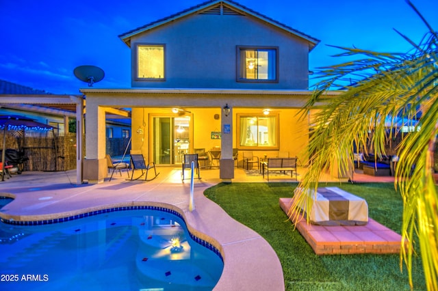 rear view of property with outdoor lounge area, a fenced in pool, fence, and a patio
