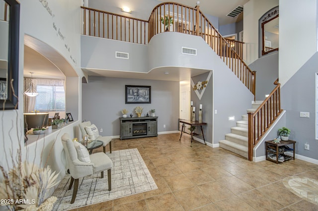foyer entrance featuring baseboards, visible vents, and stairway