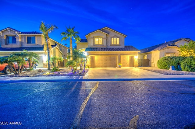 view of front of property with a tiled roof, stucco siding, driveway, and a garage
