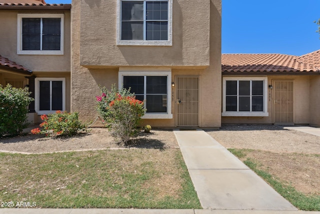 4601 N 102nd Ave Unit 1055, Phoenix, AZ 85037 - view of front of house with stucco siding, a tiled roof, and a front yard