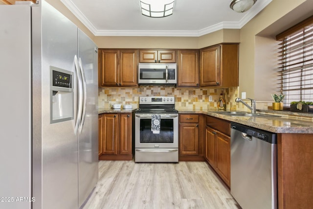 4601 N 102nd Ave Unit 1055, Phoenix, AZ 85037 - kitchen with stainless steel appliances, brown cabinets, a sink, light wood finished floors, and stone countertops
