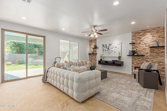 living room with light tile patterned flooring, ceiling fan, and a fireplace