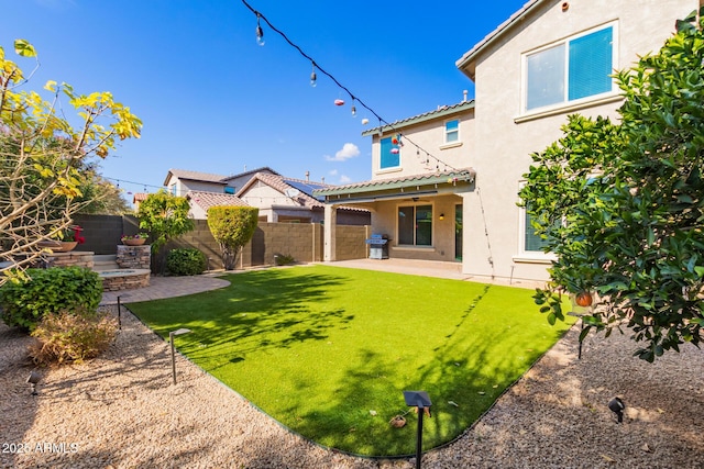 rear view of property featuring a yard and a patio