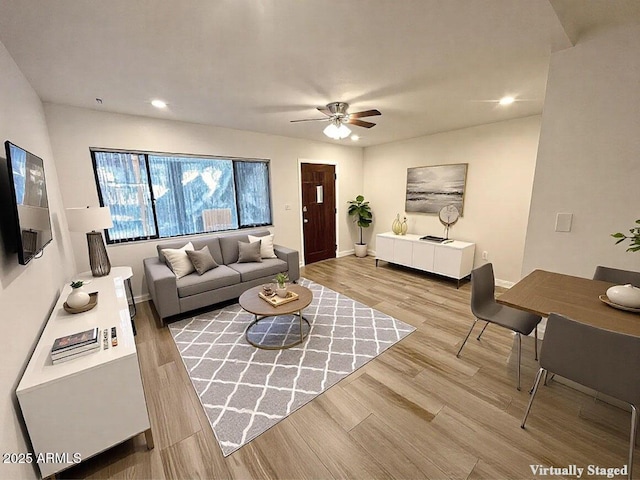 living room featuring light hardwood / wood-style floors and ceiling fan