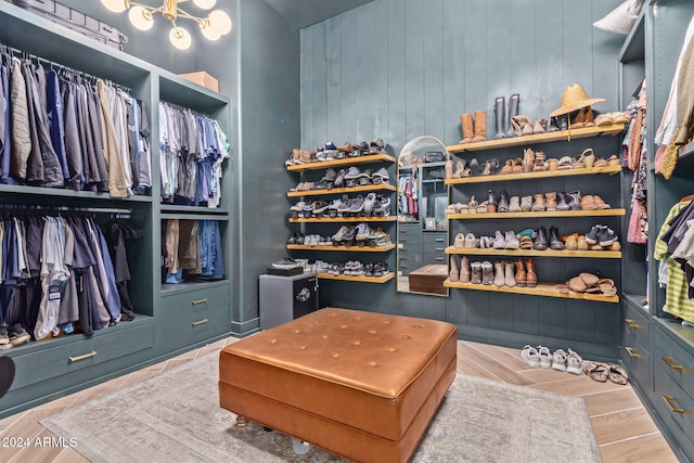 walk in closet with light hardwood / wood-style flooring