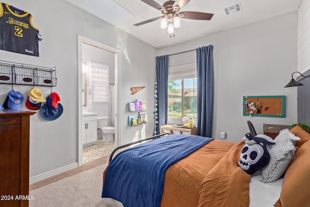 carpeted bedroom featuring ceiling fan and ensuite bath