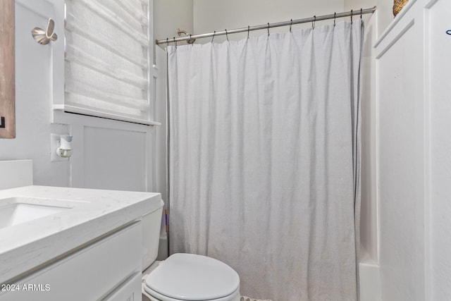 full bathroom featuring toilet, shower / tub combo with curtain, and vanity