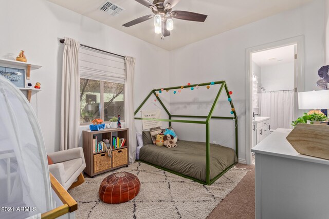 carpeted bedroom featuring ceiling fan and ensuite bath