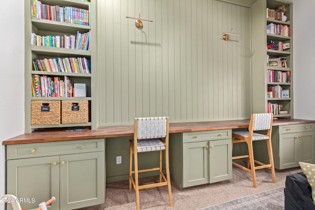 carpeted home office with built in desk