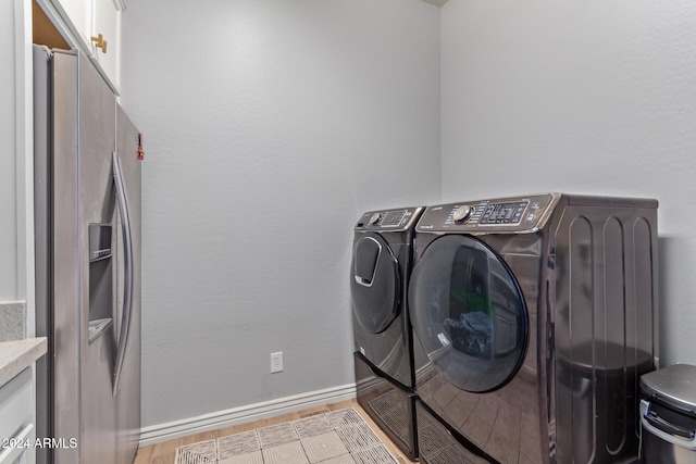 clothes washing area with light hardwood / wood-style floors and independent washer and dryer