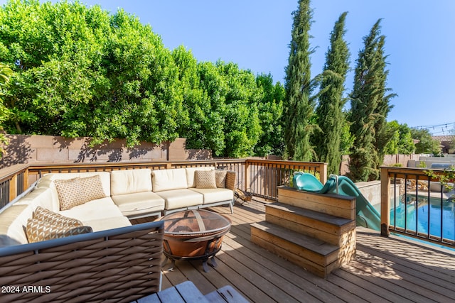 deck with outdoor lounge area and a fenced in pool