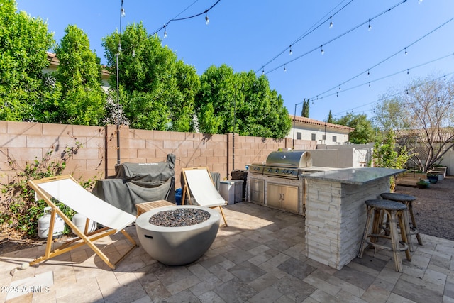 view of patio featuring a bar, an outdoor kitchen, and a grill