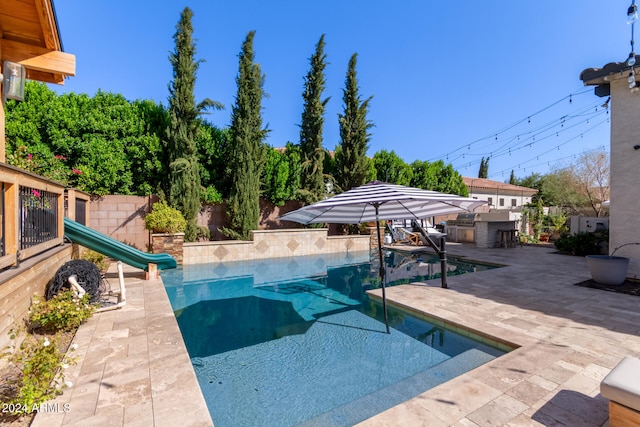 view of swimming pool featuring a patio and a water slide