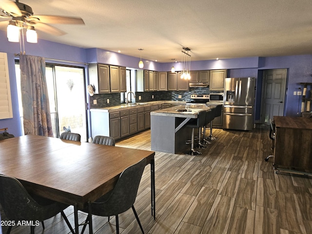 dining room with hardwood / wood-style flooring, ceiling fan, and sink