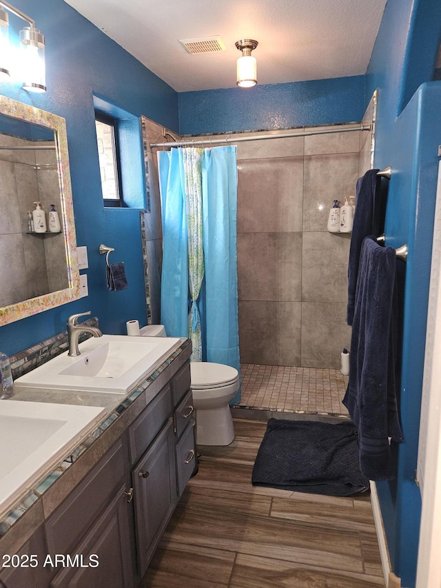 bathroom with toilet, a shower with shower curtain, and vanity