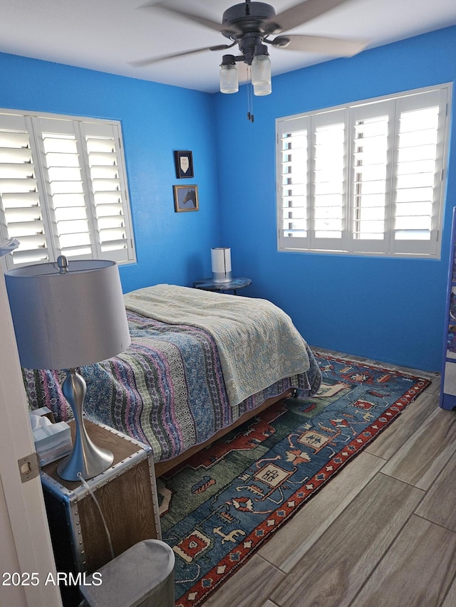 bedroom with ceiling fan and multiple windows