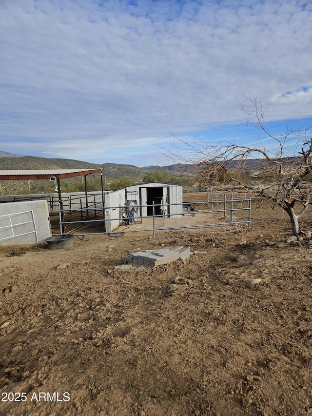 view of yard with a mountain view, a rural view, and an outdoor structure