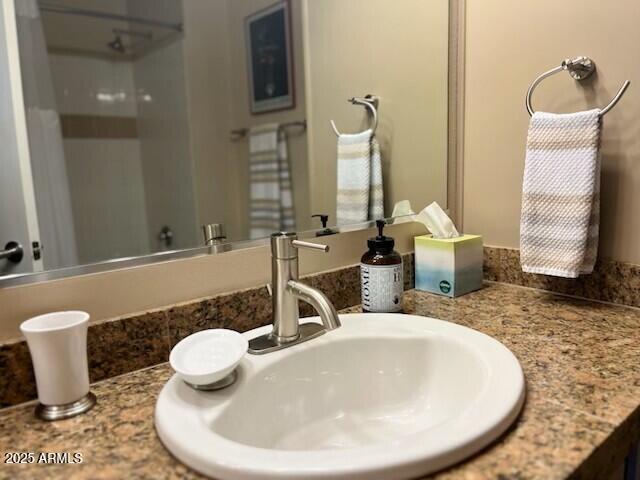 bathroom featuring a shower and vanity