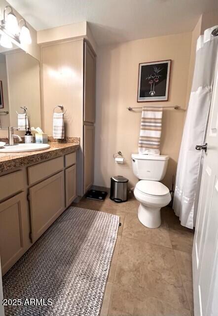 bathroom featuring toilet, vanity, and tile patterned flooring