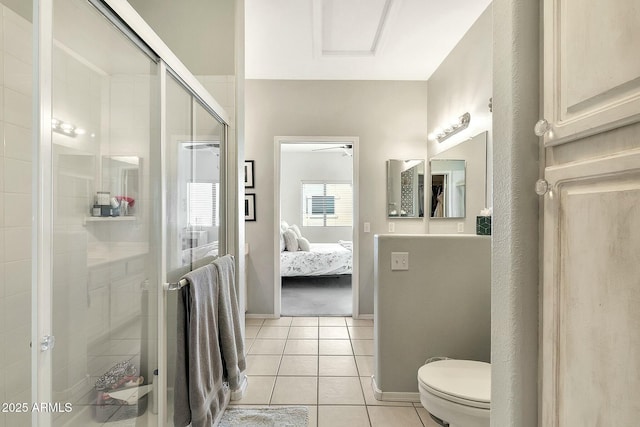 ensuite bathroom featuring tile patterned flooring, a shower stall, baseboards, toilet, and ensuite bath