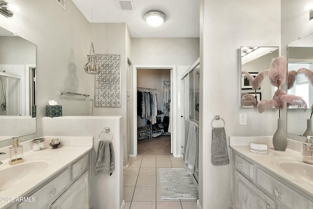 full bath featuring visible vents, two vanities, a sink, a shower stall, and tile patterned floors