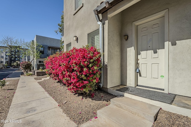 doorway to property featuring stucco siding