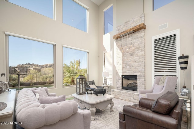 living room featuring a fireplace and a high ceiling